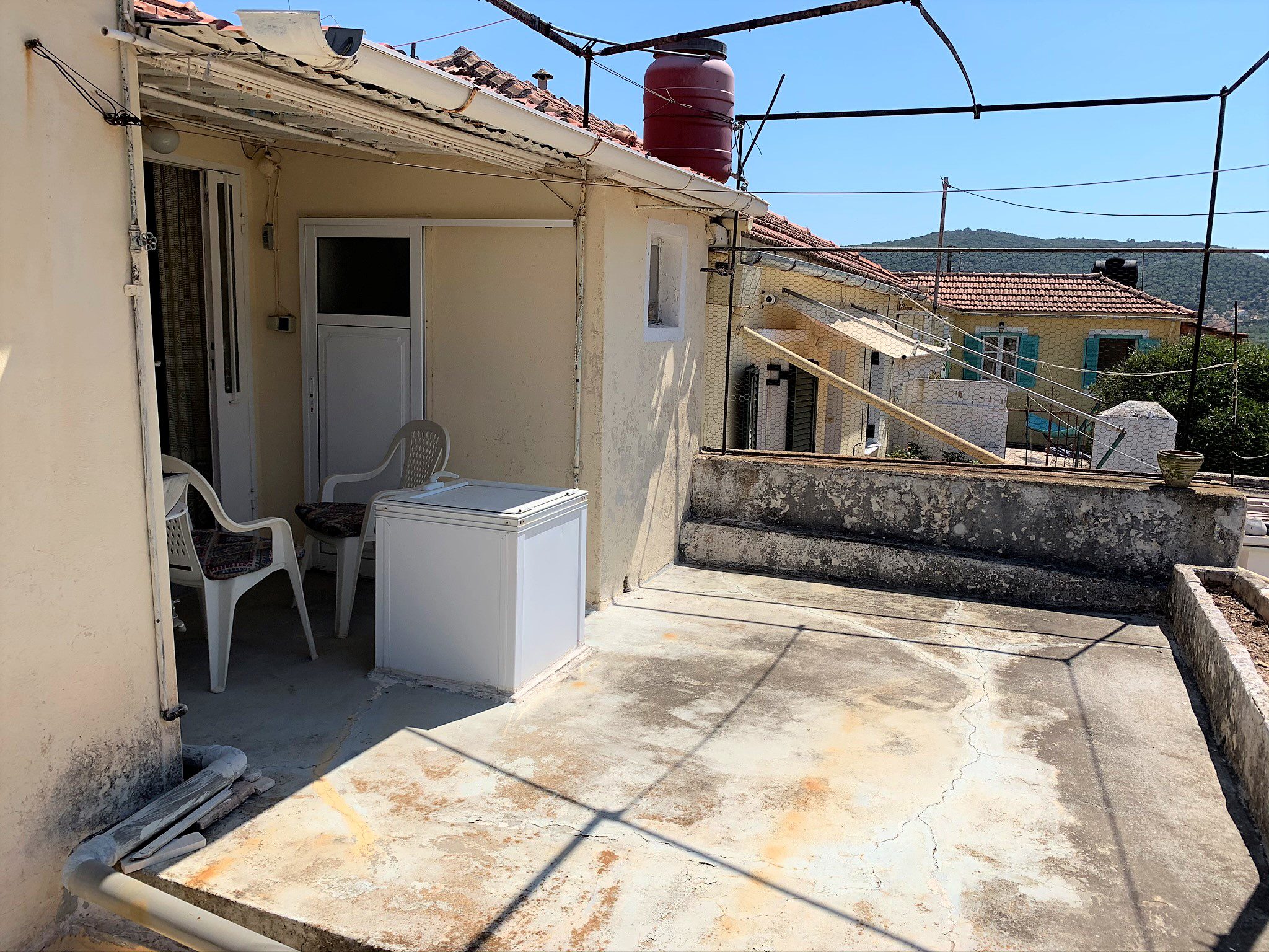 Exterior facade and outside terrace of house for sale in Ithaca Greece, Vathi