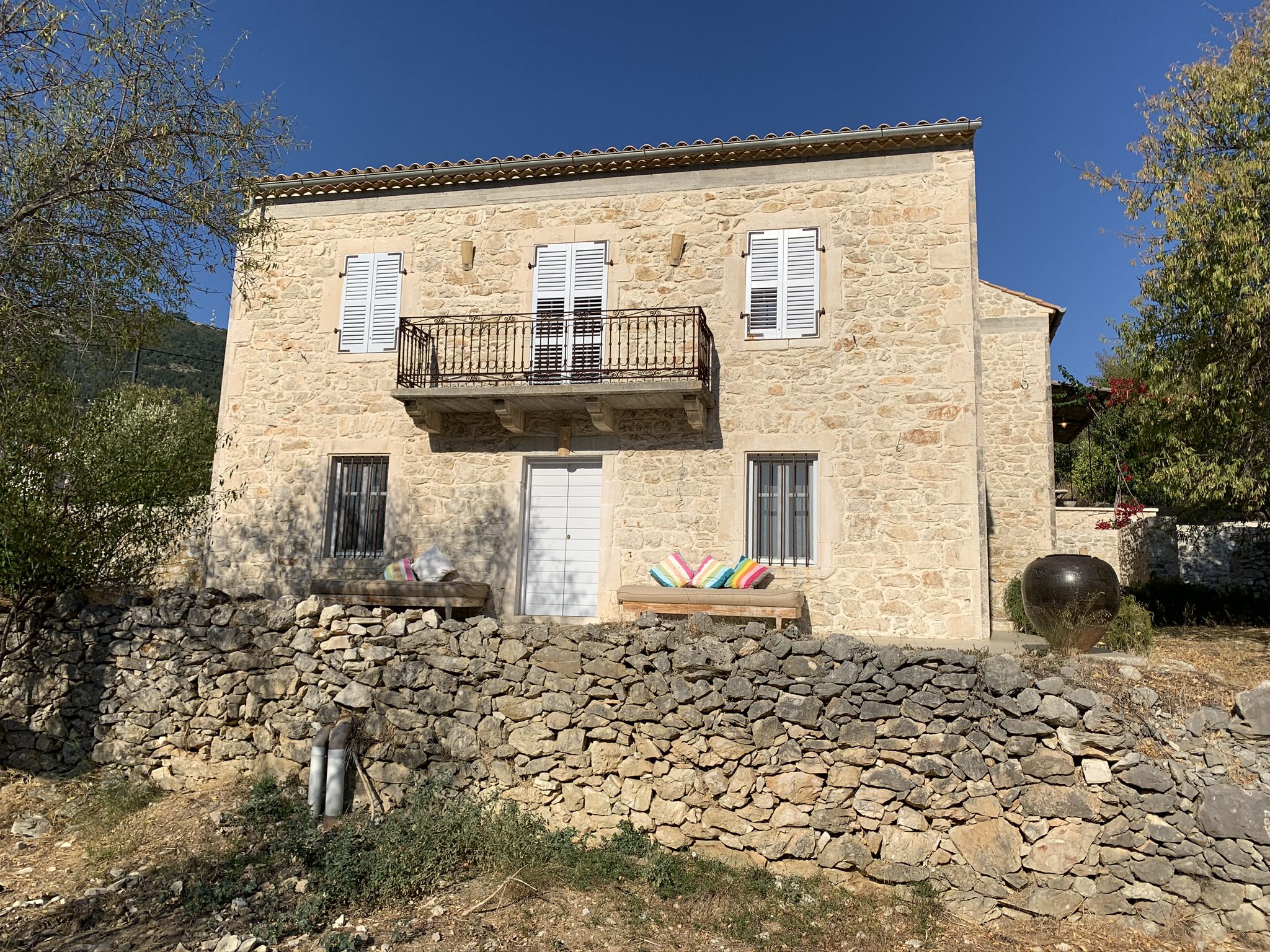 Exterior facade of stone built Villa Kalos and outside courtyard for rent, Ithaca Greece Lahos