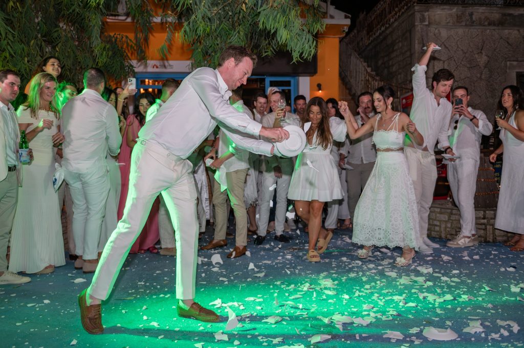 Groom smashing the plates at Greek wedding party in Ithaca Greece, Frikes