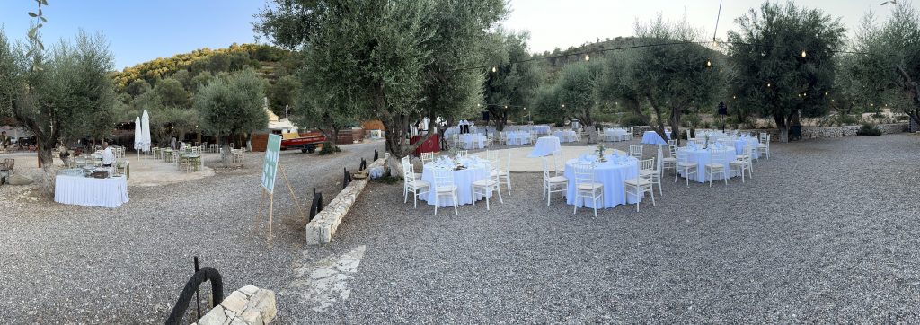 Panoramic view of table setting at beach wedding reception in Ithaca Greece, Vathi