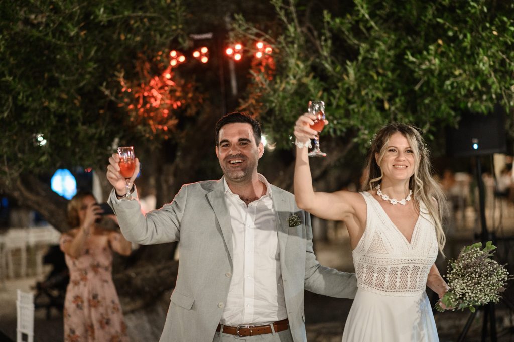 Couple toasting at waterfront wedding reception in Ithaca Greece, Vathi